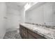 Bathroom features a double sink granite countertop on cabinets and decorative tile flooring at 5710 N 84Th Ave, Glendale, AZ 85305