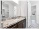 Bathroom with dark cabinets, granite counters, and a decorative tiled floor at 5710 N 84Th Ave, Glendale, AZ 85305