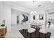 Bright dining room with a glass table, white chairs, and a decorative chandelier at 5710 N 84Th Ave, Glendale, AZ 85305