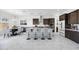 Beautiful open kitchen features granite countertops, dark wood cabinets, and a center island with seating at 5710 N 84Th Ave, Glendale, AZ 85305