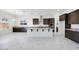 Spacious kitchen featuring dark wood cabinets, white marble floors, a large island and stainless steel appliances at 5710 N 84Th Ave, Glendale, AZ 85305