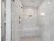 Glass-walled shower with overhead and handheld shower heads and built-in seat at 5710 N 84Th Ave, Glendale, AZ 85305