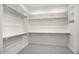 Spacious walk-in closet with built-in shelving and hanging rods at 5710 N 84Th Ave, Glendale, AZ 85305