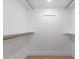 Walk-in closet with built in shelving and light wood floors at 6349 N 78Th St # 123, Scottsdale, AZ 85250