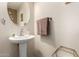 Elegant powder room with pedestal sink, round mirror, and stylish accessories at 650 E Daniella E Dr, San Tan Valley, AZ 85140