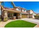 Two-story home featuring a charming front porch, two-car garage, tile roof, and low-maintenance desert landscaping at 650 E Daniella E Dr, San Tan Valley, AZ 85140