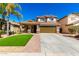 Two-story home featuring a charming front porch, two-car garage, tile roof, and low-maintenance desert landscaping at 650 E Daniella E Dr, San Tan Valley, AZ 85140