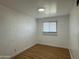 Bright bedroom with window and wood floors, featuring white painted brick walls at 7129 W Meadowbrook Ave, Phoenix, AZ 85033