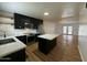 Modern kitchen features sleek black cabinets, stainless steel appliances, and a spacious island with quartz countertops at 7129 W Meadowbrook Ave, Phoenix, AZ 85033