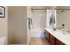Bright bathroom features a shower-tub combo, wood vanity with dual sinks, and neutral color palette at 8359 E Ingram Cir, Mesa, AZ 85207
