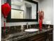 Bathroom featuring an elegant dark granite countertop and decorative mirror at 8369 E Del Camino Dr, Scottsdale, AZ 85258