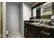 Bathroom vanity with dark wood cabinets, granite countertops, and decorative mirror at 8369 E Del Camino Dr, Scottsdale, AZ 85258