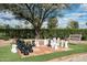 Outdoor chess board with oversized pieces, surrounded by lush greenery and a park bench at 8369 E Del Camino Dr, Scottsdale, AZ 85258
