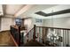 Second-story foyer with wood railing overlooking the living space with chandelier at 8369 E Del Camino Dr, Scottsdale, AZ 85258
