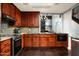 Well-equipped kitchen with dark wood cabinets, tile backsplash, and stainless steel appliances at 8369 E Del Camino Dr, Scottsdale, AZ 85258