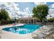 Community pool with clear water, lounge chairs, and shaded pavilion on a sunny day at 8369 E Del Camino Dr, Scottsdale, AZ 85258