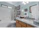 Bathroom with a combination shower/tub and a wooden vanity topped with a marble countertop at 8568 W Purdue Ave, Peoria, AZ 85345