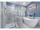 Bathroom featuring a free standing tub and walk-in shower with glass doors and tile surround at 8568 W Purdue Ave, Peoria, AZ 85345