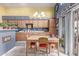 Eat-in kitchen featuring wooden cabinetry, a chandelier, and a sliding door to the backyard, perfect for indoor-outdoor living at 8568 W Purdue Ave, Peoria, AZ 85345