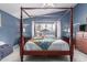Main bedroom with a four-poster bed, vibrant quilt, and views of the outdoors, offering a cozy and inviting ambiance at 8568 W Purdue Ave, Peoria, AZ 85345