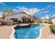 A refreshing backyard pool surrounded by desert landscaping and a covered patio, perfect for outdoor living at 8568 W Purdue Ave, Peoria, AZ 85345