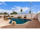 Relaxing backyard oasis featuring a sparkling swimming pool with a stone edge and desert landscaping at 8568 W Purdue Ave, Peoria, AZ 85345
