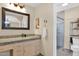 Well-lit bathroom featuring granite counters, a large mirror, and a glass-enclosed shower at 9740 W Rockwood Dr, Peoria, AZ 85382