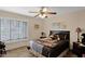 Cozy bedroom featuring a ceiling fan, decorative pillows, and bright natural light at 9740 W Rockwood Dr, Peoria, AZ 85382