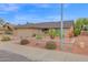 Well-maintained home showcasing desert landscaping, a spacious driveway, and an inviting front entrance at 9740 W Rockwood Dr, Peoria, AZ 85382