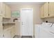 Functional laundry room equipped with ample cabinet space, tiled floor, and modern machines at 9740 W Rockwood Dr, Peoria, AZ 85382