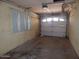 Attached garage with a roll-up door and overhead lighting at 10319 W Willie Low Cir, Sun City, AZ 85351