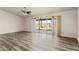 Bright and airy living room with modern wood-look floors, sliding glass doors, and a view of the backyard desert landscape at 10440 W Devonshire Ave, Phoenix, AZ 85037