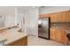 Well-lit kitchen with stainless steel refrigerator, light cabinetry, and a convenient layout at 15026 W Cactus Ridge Way, Surprise, AZ 85374