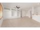 Expansive living area with neutral tile flooring, built-in shelves, and bright white walls at 15026 W Cactus Ridge Way, Surprise, AZ 85374