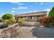 Beautifully landscaped backyard with colorful flowers, gravel landscaping and a covered patio at 15560 W Clear Canyon Dr, Surprise, AZ 85374