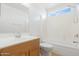 Bathroom with a shower-tub combo, single sink vanity, wood cabinets, and neutral colored floors at 1563 S 227Th Ave, Buckeye, AZ 85326