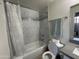 Bathroom featuring a tub with tiled surround, toilet, and a mirror with vanity lights at 1701 E Colter St # 138, Phoenix, AZ 85016