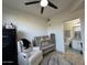 Bright bedroom featuring a crib, chair, ceiling fan, and an en-suite bathroom with updated fixtures at 1701 E Colter St # 138, Phoenix, AZ 85016