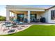 A spacious covered patio with outdoor seating, a barbecue grill, and a view of the landscaped backyard at 1775 N 164Th Dr, Goodyear, AZ 85395