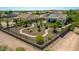 Aerial view of a landscaped backyard with desert landscaping, walkways, covered patio, and wrought iron style fencing at 1775 N 164Th Dr, Goodyear, AZ 85395