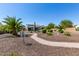 Expansive backyard featuring desert landscaping, a meandering pathway, and mature palm trees at 1775 N 164Th Dr, Goodyear, AZ 85395