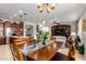 Open dining area with a wooden table, seating, and adjacent living area with media center at 1775 N 164Th Dr, Goodyear, AZ 85395