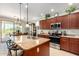 Eat in kitchen with island, stainless steel appliances, cherry cabinets, and sliding glass doors at 1775 N 164Th Dr, Goodyear, AZ 85395