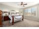 Relaxing main bedroom featuring soft carpet, a ceiling fan, and large shuttered windows at 1775 N 164Th Dr, Goodyear, AZ 85395