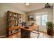 Charming home office with stylish desk, shelving unit, hardwood floors and plenty of natural light at 23217 N 22Nd Pl, Phoenix, AZ 85024