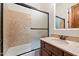 Bathroom featuring a shower-tub combo with glass doors and a stone countertop vanity at 2333 N 87Th Pl, Mesa, AZ 85207