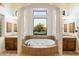 This stunning bathroom boasts dual vanities, a soaking tub with a garden view, and natural light at 2333 N 87Th Pl, Mesa, AZ 85207