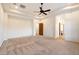 Large bedroom featuring neutral carpet, ceiling fan, and open doorways to other rooms of the house at 2333 N 87Th Pl, Mesa, AZ 85207