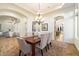 Elegant dining room boasts modern chandelier, neutral colors, and a glass-topped table with seating for six at 2333 N 87Th Pl, Mesa, AZ 85207