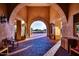 Arched entryway with views of lush landscaping, brick walkway, and stone features at 2333 N 87Th Pl, Mesa, AZ 85207